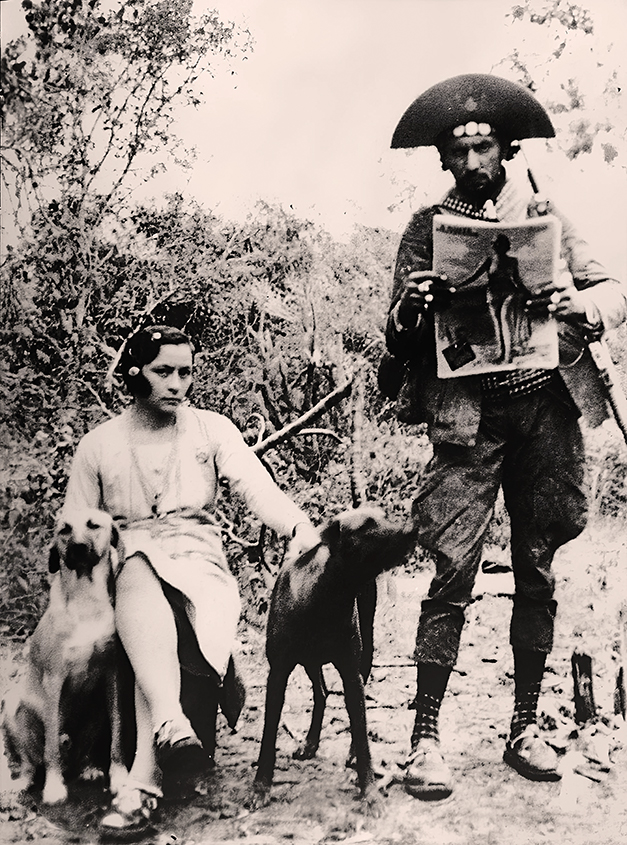 Maria e Lampião com os cães Guarani e Dourado. Ele mostra 
exemplar da revista 'A Noite Ilustrada'/ Foto: Benjamin Abrahão